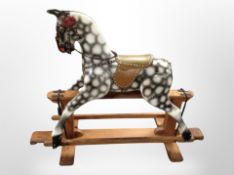 A painted rocking horse on pine stand,