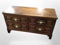 A contemporary oak effect four drawer low chest,