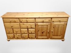 A pine sideboard fitted with fourteen drawers and cupboard,