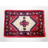 A small Iranian fringed rug 64 cm x 42 cm