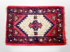 A small Iranian fringed rug 64 cm x 42 cm