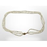 A triple strand cultured pearl necklace on 14ct yellow gold clasp,