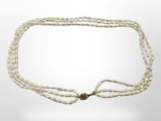 A triple strand cultured pearl necklace on 14ct yellow gold clasp,