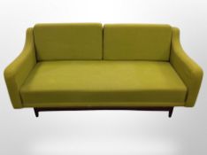 A 20th century Scandinavian three seater settee in green upholstery,