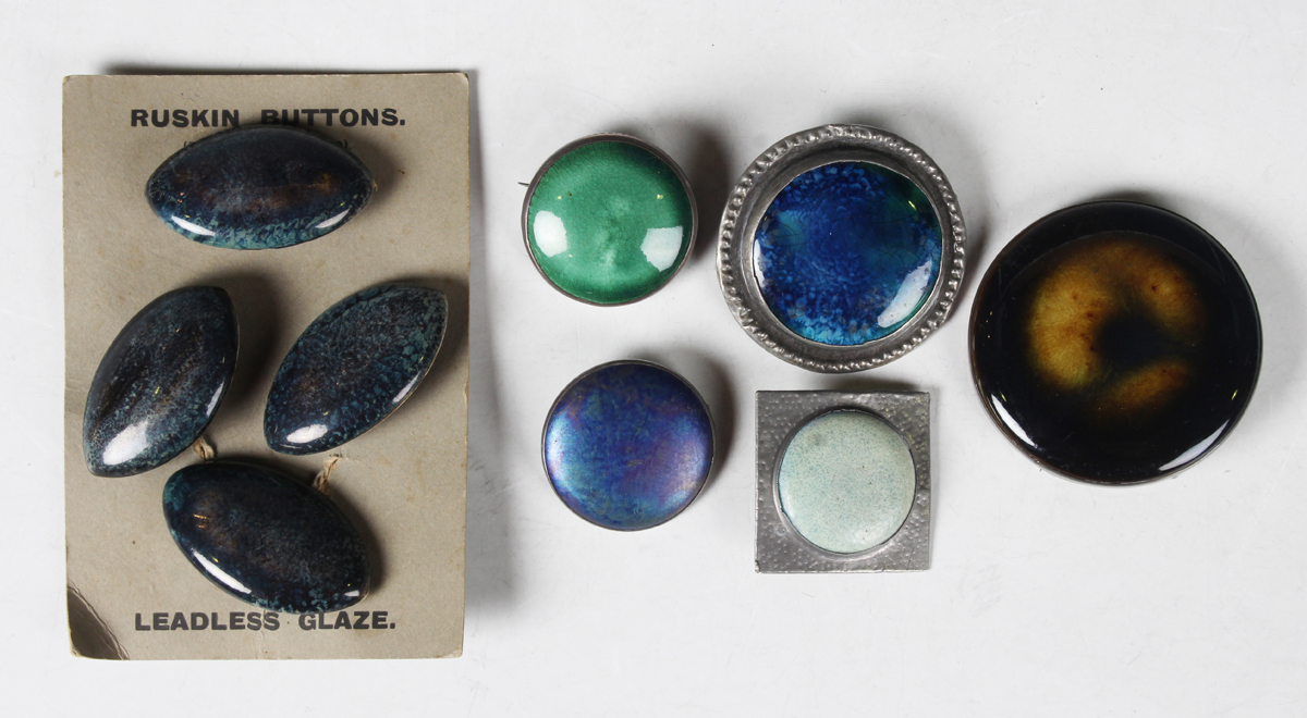 A set of four Ruskin marquise shaped pottery buttons on their original card, with mottled dark