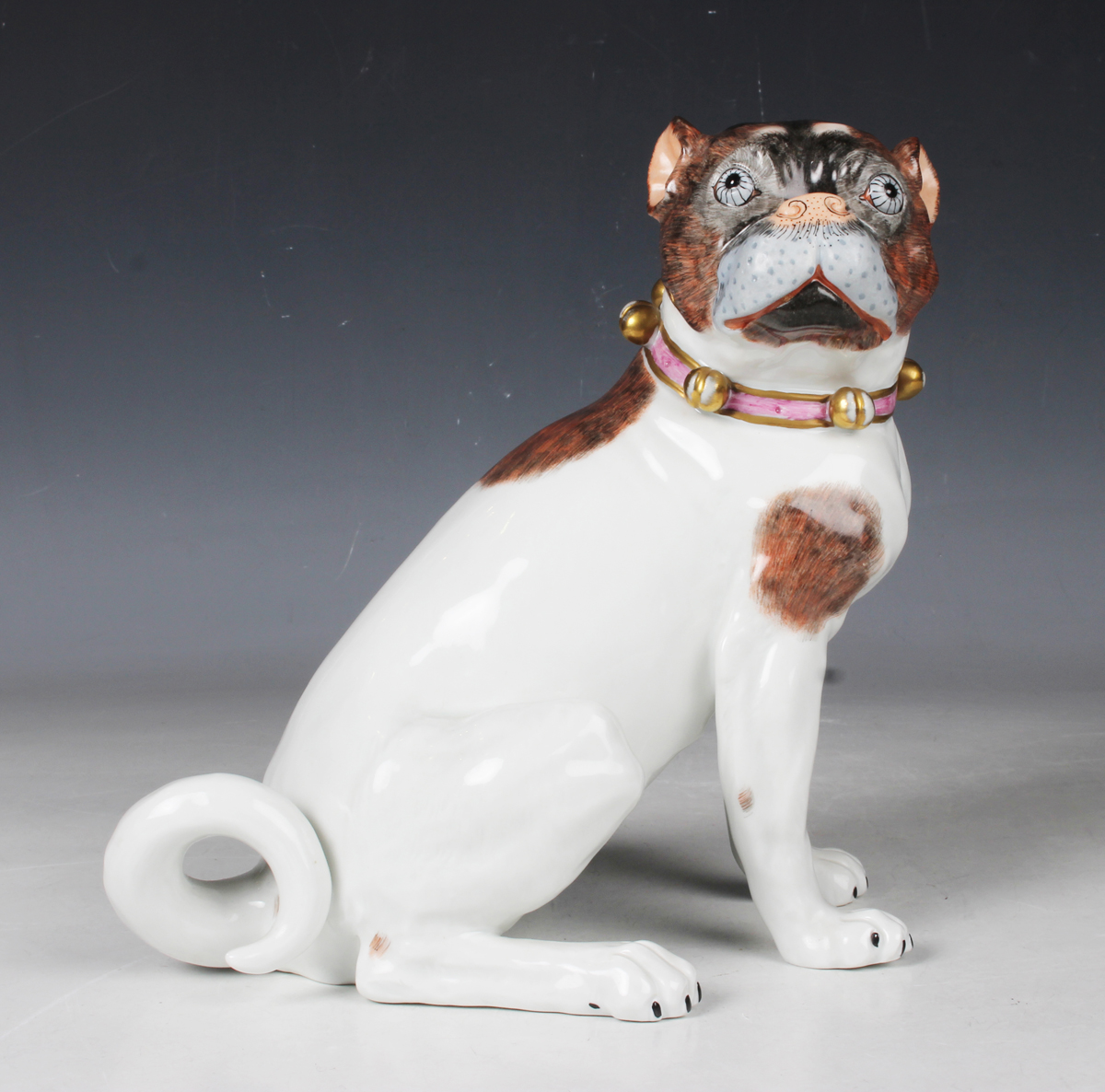 A Dresden porcelain Meissen style model of a pug, 20th century, typically modelled seated and