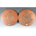 A pair of early to mid-20th century carved wood circular plaques, each with a crown above a