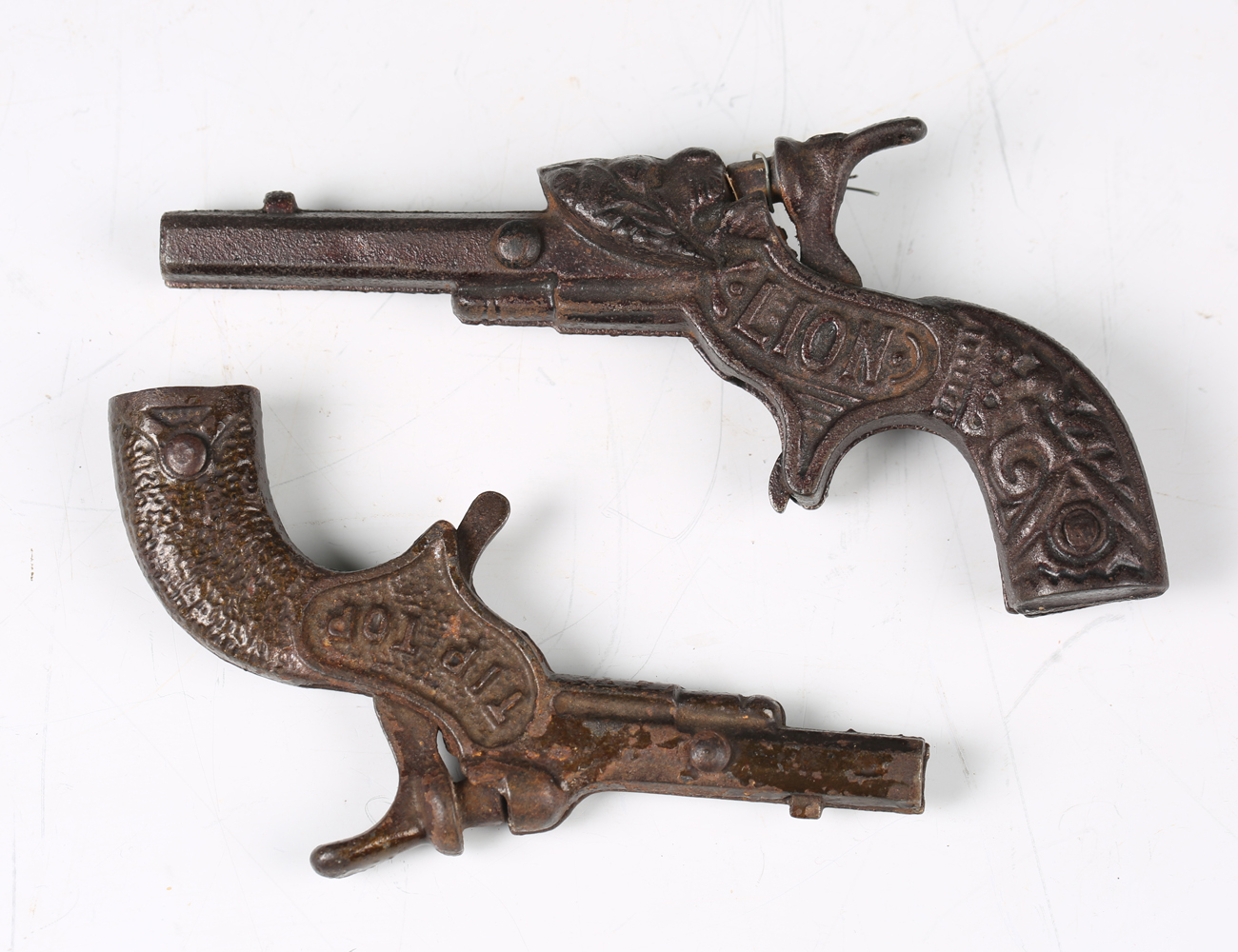 Two late 19th/early 20th century cast metal toy cap guns, one detailed 'Lion', length 13cm, the