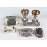 A Victorian silver curved rectangular purse with engraved scroll decoration, the interior fitted