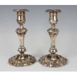 A pair of George IV silver candlesticks, each with detachable nozzles and decorated with rococo