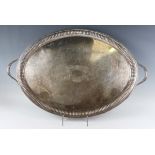 A late Victorian silver oval two-handled tea tray, the centre engraved with an oval vacant cartouche