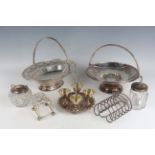 A group of plated items, including two swing handle cake baskets, a candelabrum, two toast racks and