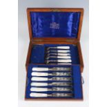 A set of six Edwardian silver and mother-of-pearl handled dessert knives and forks, engraved with