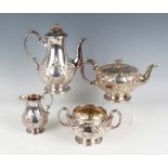 A Victorian silver harlequin four-piece tea set, each of circular form with flower finial above