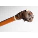 A 19th century satin birch walking cane, the carved softwood automated handle modelled in the form