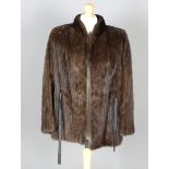 A late 20th century mink half-length coat by Saga with applied leather belt straps, size 14.Buyer’