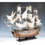 A late 20th century wooden kit-built model of HMS Victory, well-detailed with cloth sails, raised on