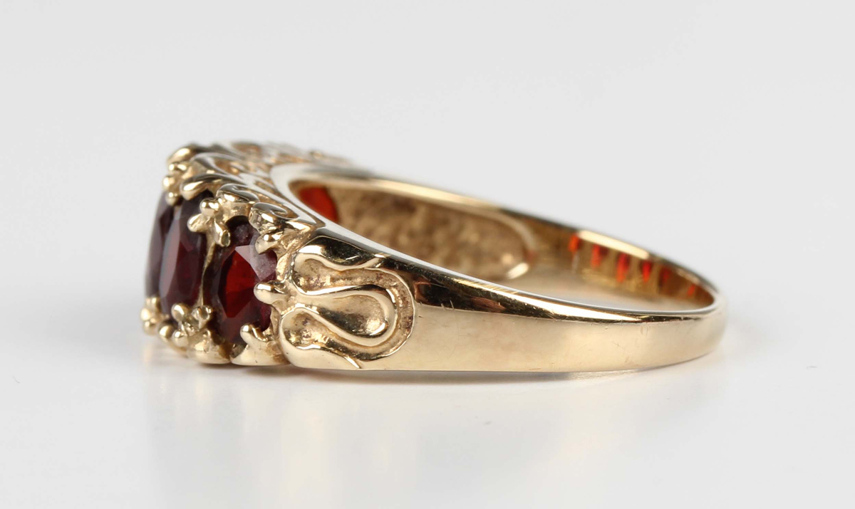 A 9ct gold and garnet five stone ring, claw set with a row of oval cut garnets graduating in size to - Image 4 of 5