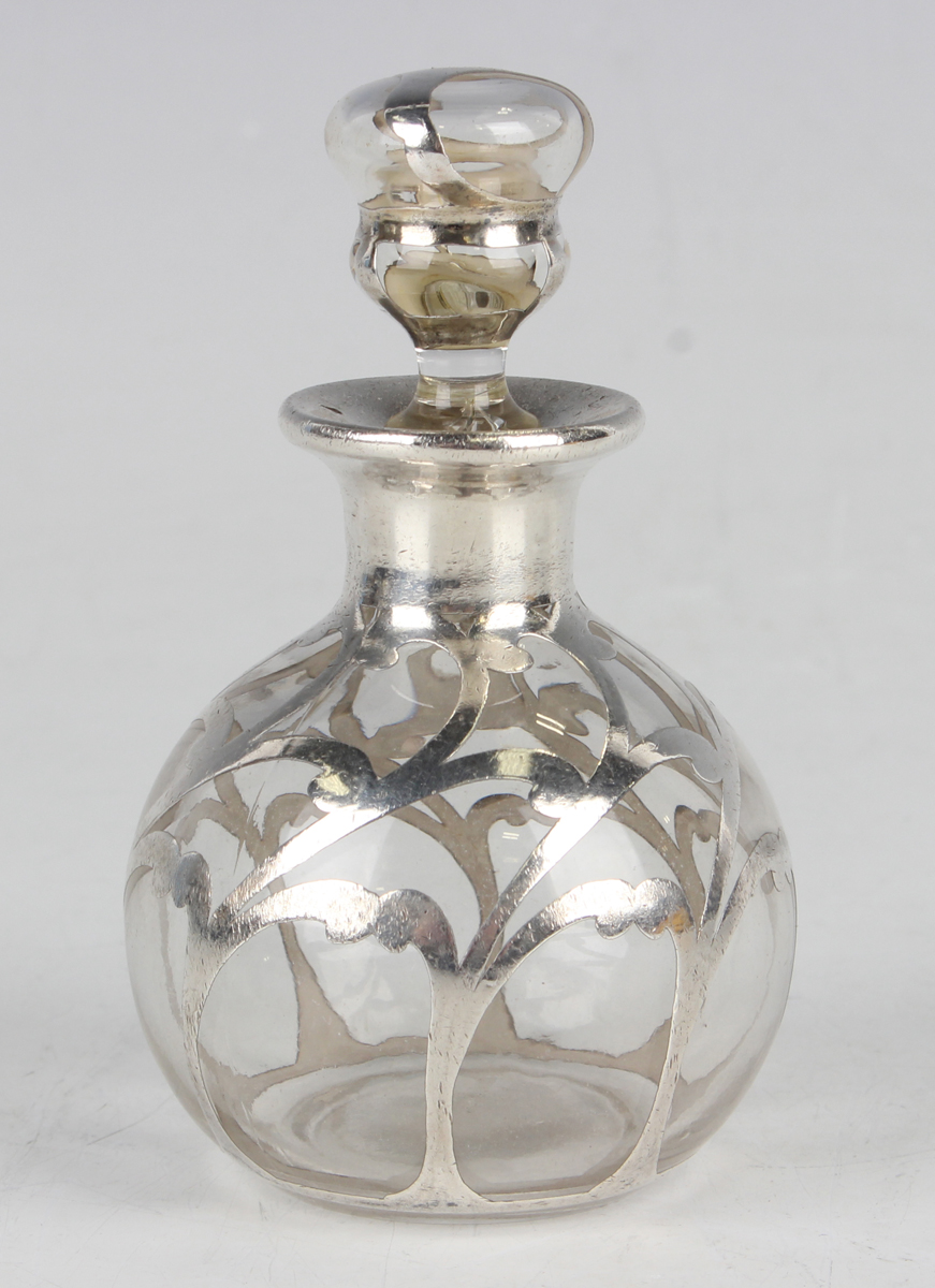 An early 20th century silver overlaid clear glass scent bottle and stopper of globular form with