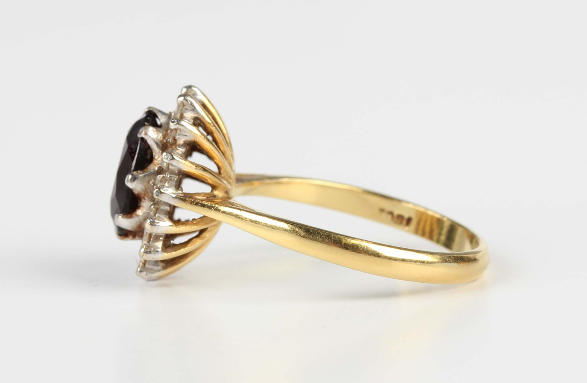 A gold, garnet and diamond cluster ring, claw set with an oval cut garnet within a surround of - Image 4 of 5