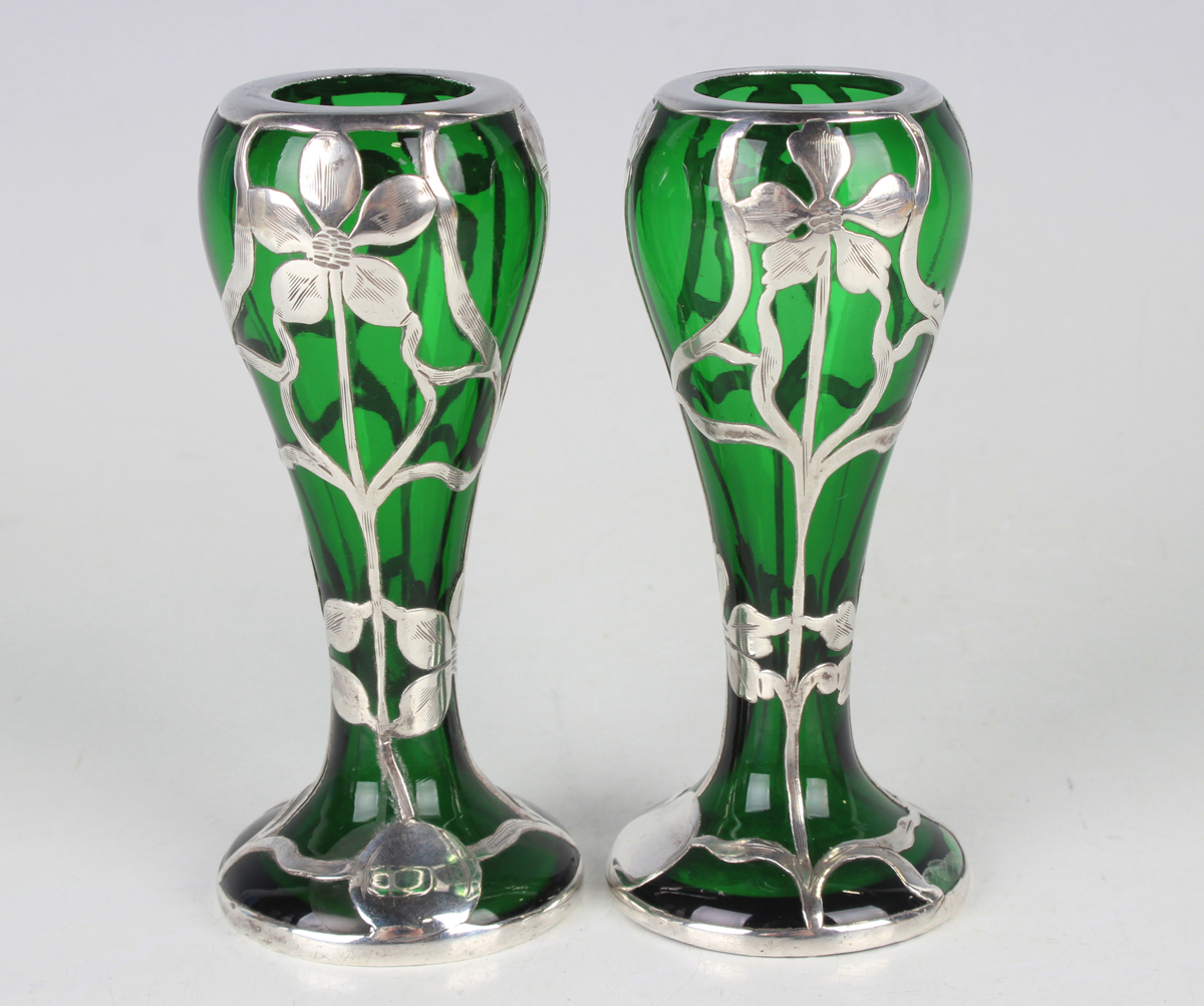 A pair of early 20th century silver overlaid green glass vases, each of slender baluster form,