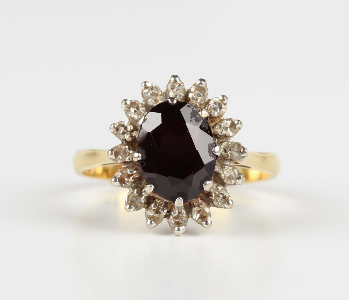 A gold, garnet and diamond cluster ring, claw set with an oval cut garnet within a surround of - Image 5 of 5