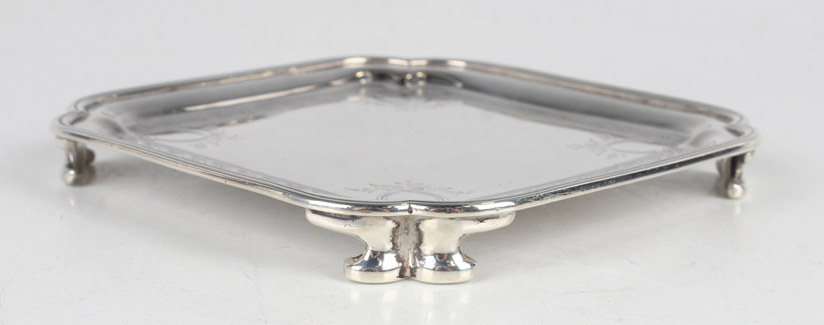 A George V silver card salver of square form with lobed corners, engraved with scrolls, raised on - Image 3 of 3