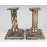 A pair of late Victorian silver candlesticks, each with a square beaded detachable nozzle above a
