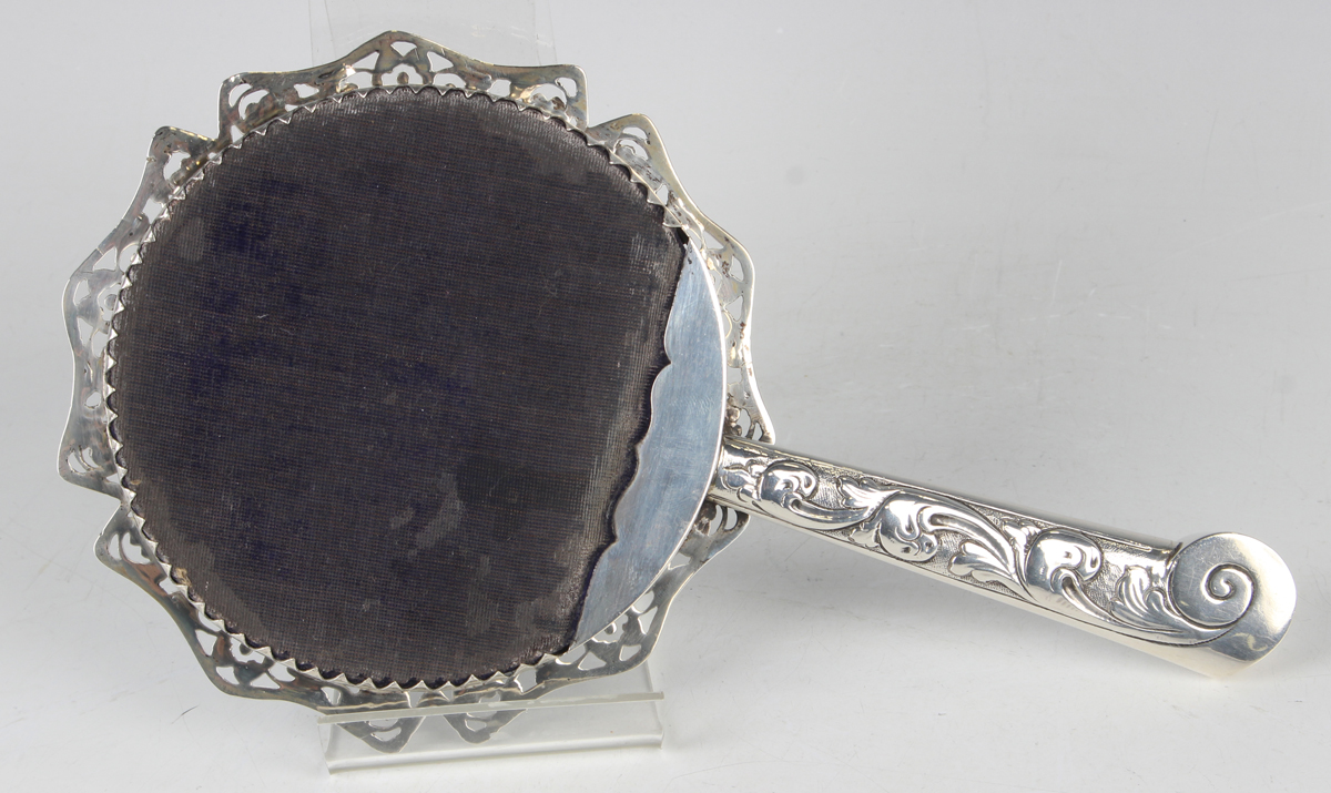 A Victorian silver mounted hand mirror with bevelled circular mirror plate within a cast and pierced - Image 3 of 3