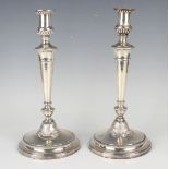 A pair of George III silver candlesticks, each sconce with reeded and foliate decoration above a