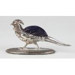 An Edwardian silver novelty pincushion in the form of an ornamental pheasant standing on an oval