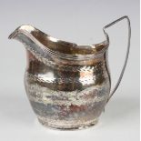 A George III silver milk jug of oval form with engraved decoration, London 1804 by John Merry,
