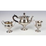 A late Victorian silver three-piece teaset of baluster form with half spiral reeded decoration,