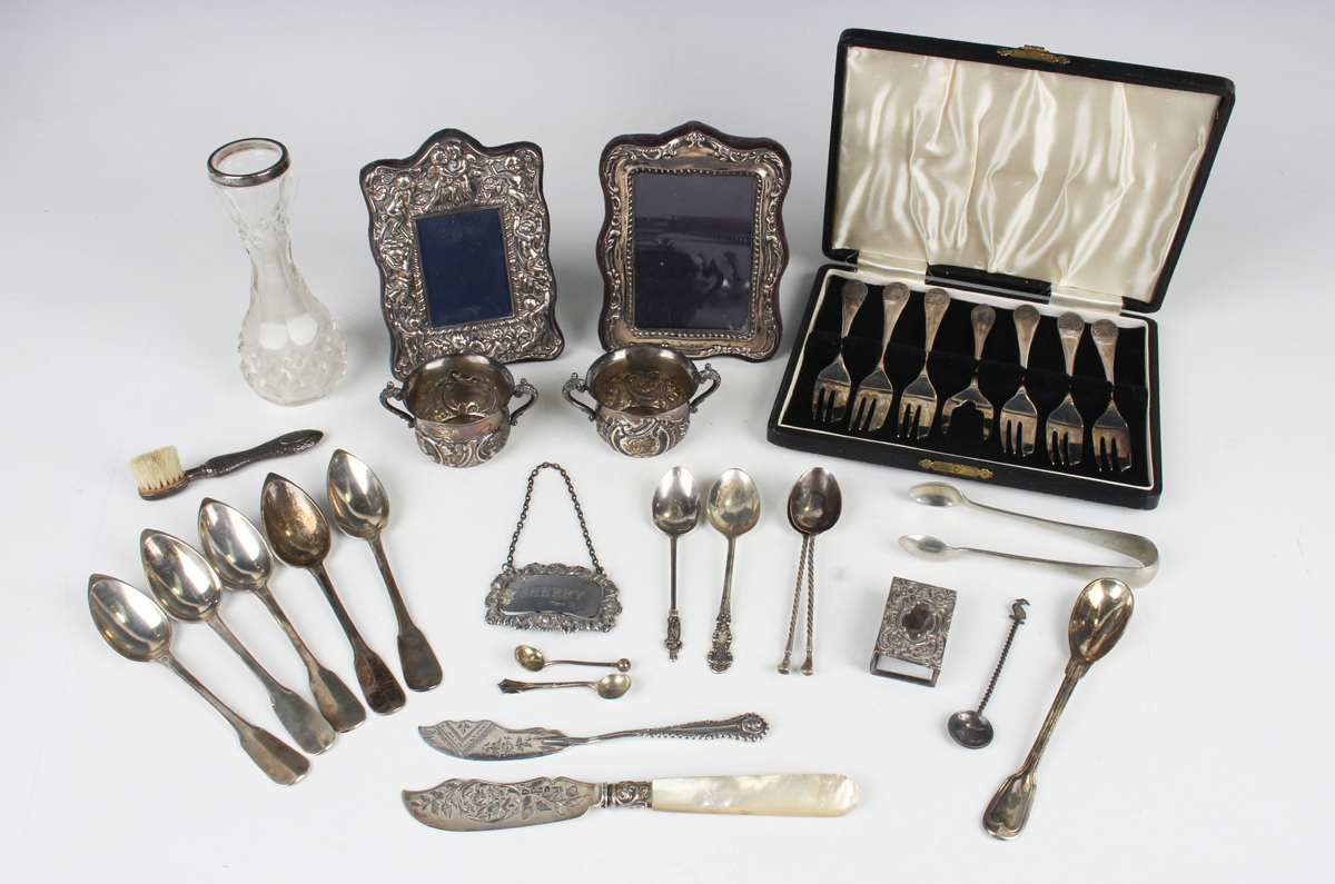 A pair of late Victorian silver circular salts, each embossed with scrolls flanked by two scroll