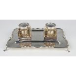 An Edwardian silver shaped rectangular inkstand on scroll feet, fitted with two square silver