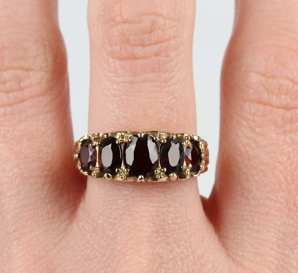 A 9ct gold and garnet five stone ring, claw set with a row of oval cut garnets graduating in size to - Image 2 of 5