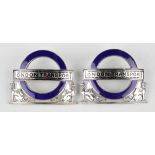 Two George V silver and blue enamelled 'London Transport' cap badges, each back detailed with a