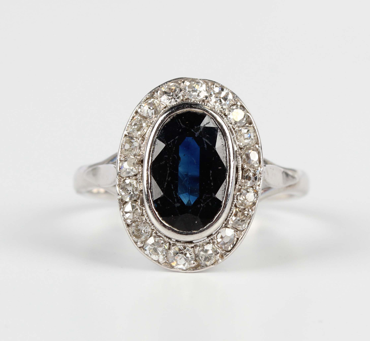 A white gold, sapphire and diamond oval cluster ring, collet set with an oval cut sapphire within - Image 5 of 5