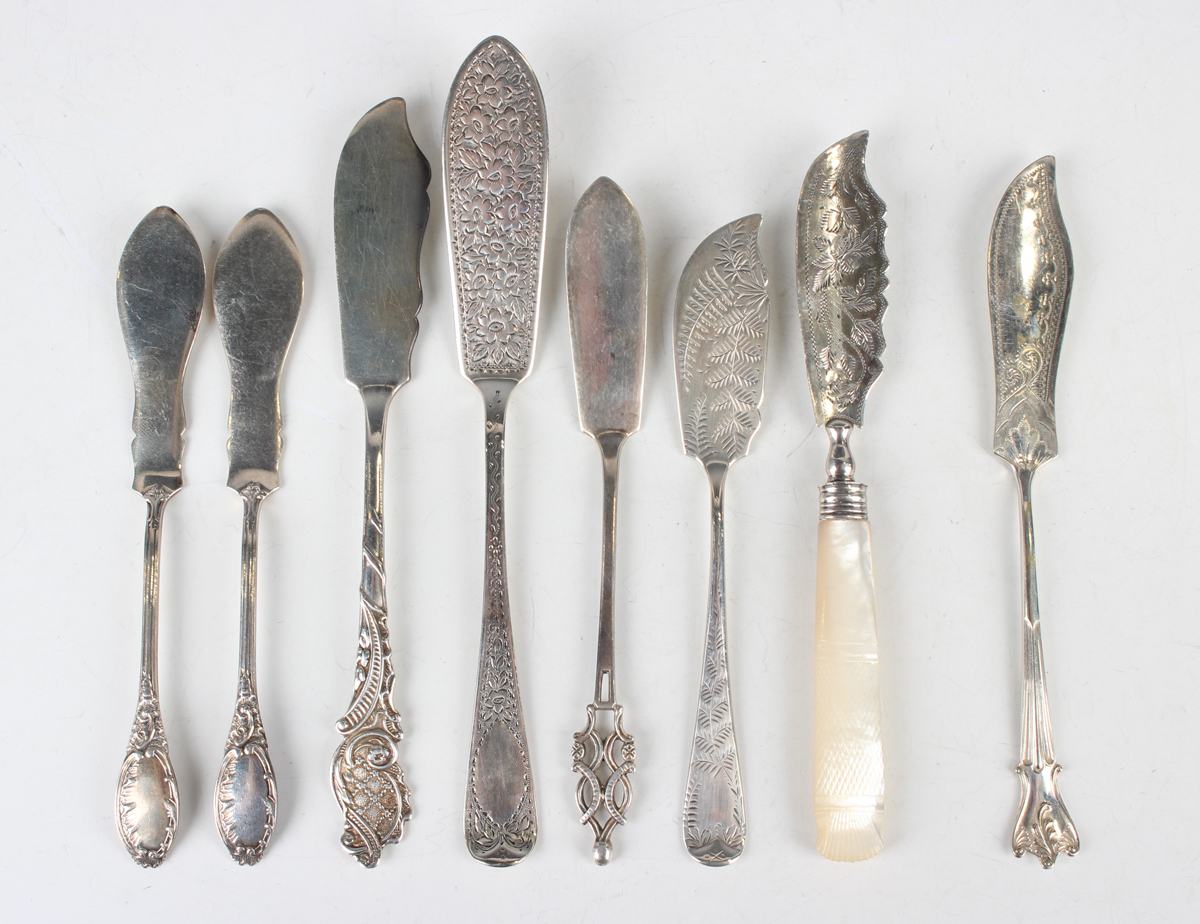 A group of seven silver butter knives, including a pair with scroll decorated handles, Sheffield