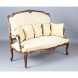 A late 19th/early 20th century French walnut framed settee, upholstered in patterned yellow