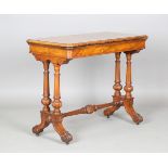 A mid-Victorian burr walnut fold-over card table, the rotating hinged top above a carved base,