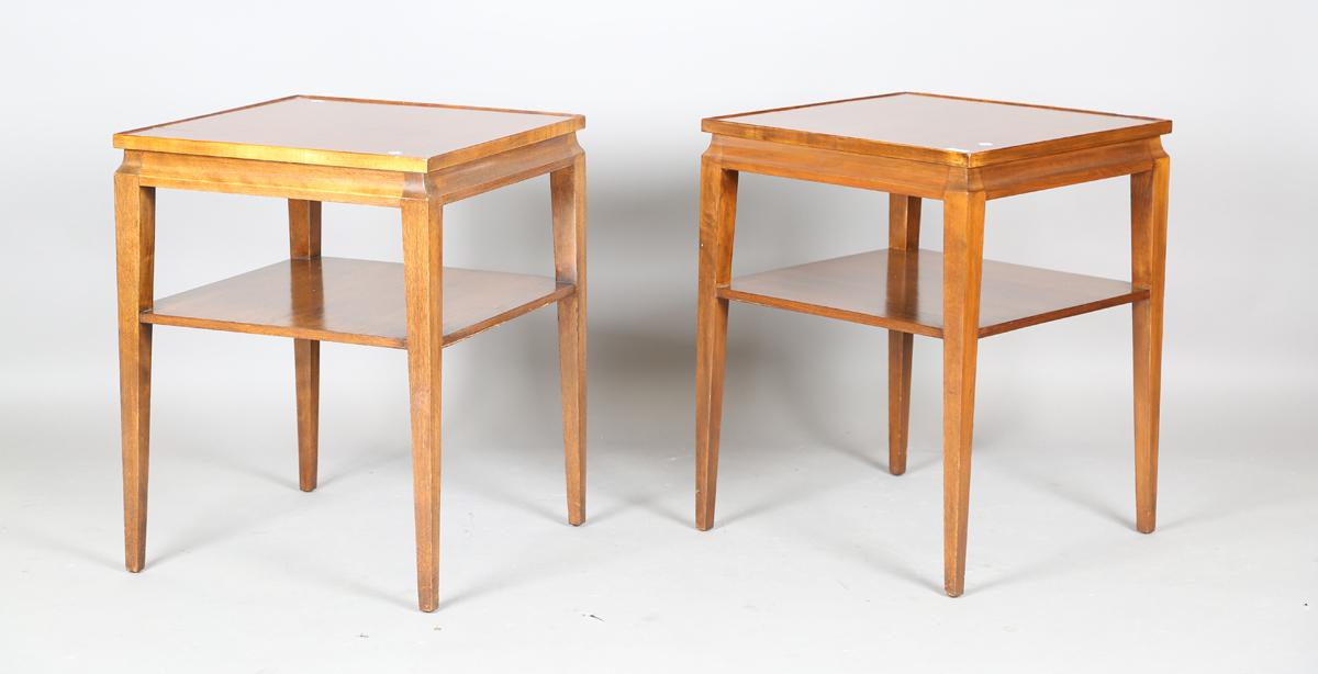 A pair of mid-20th century French mahogany lamp tables of retro design, the quarter-veneered tops