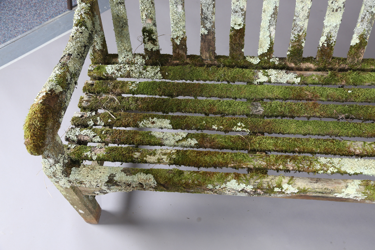 A 20th century teak garden bench, covered in green lichen, height 81cm, width 182cm, depth 70cm. - Image 9 of 11