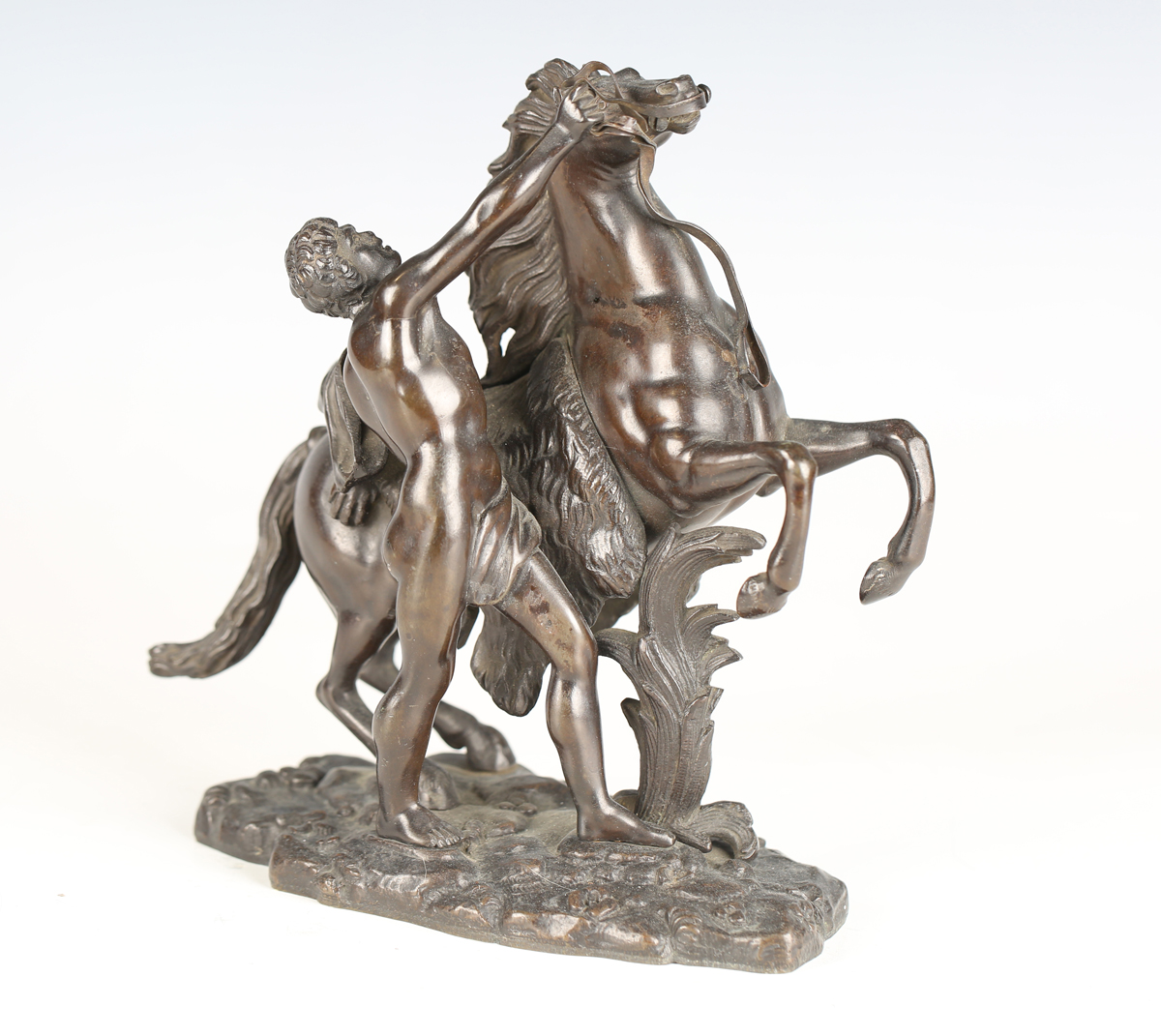 After Guillaume Coustou - a 19th century brown patinated cast bronze model of a Marly horse and