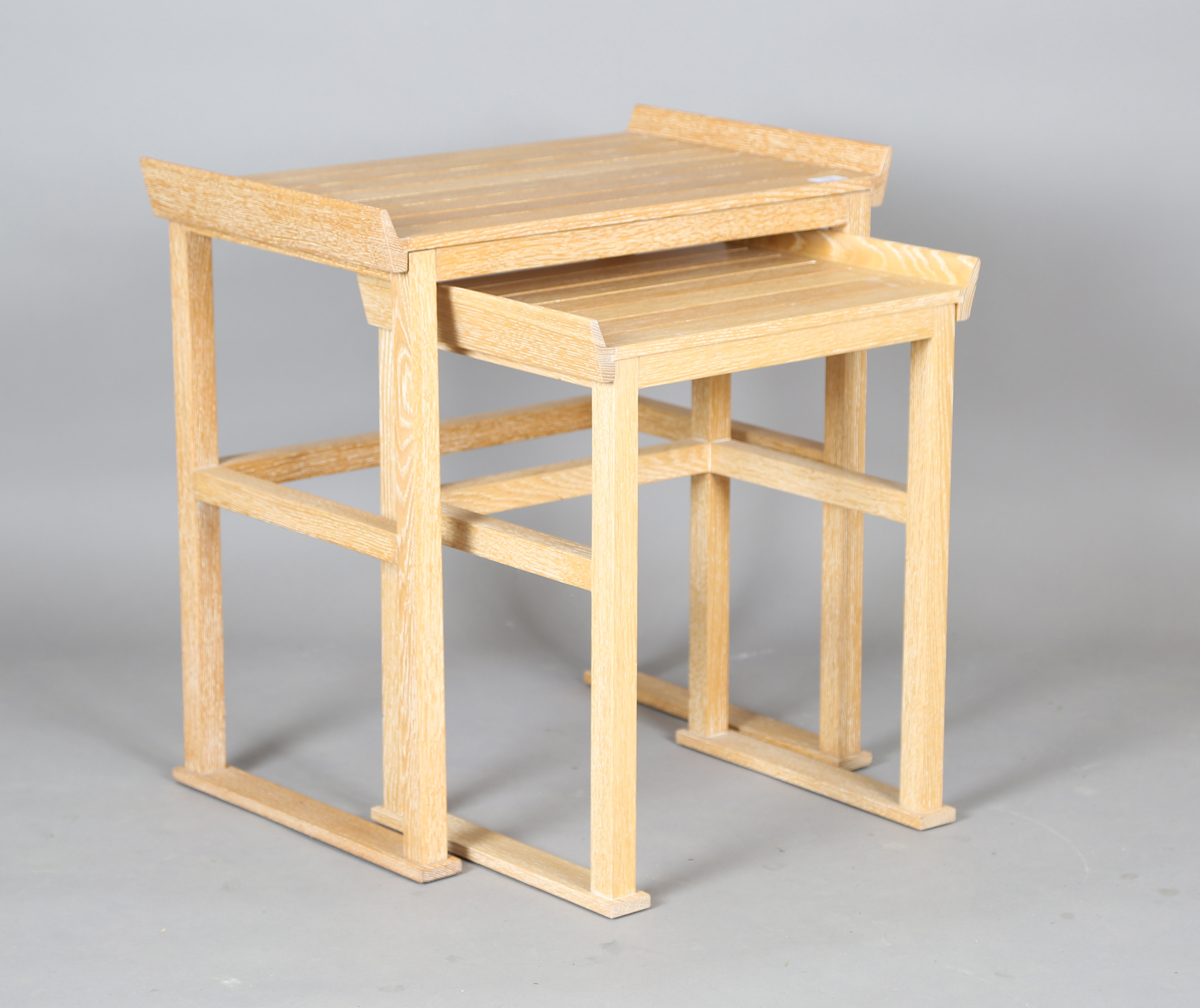 A modern limed oak nest of two occasional tables, each removable slatted tray top revealing a