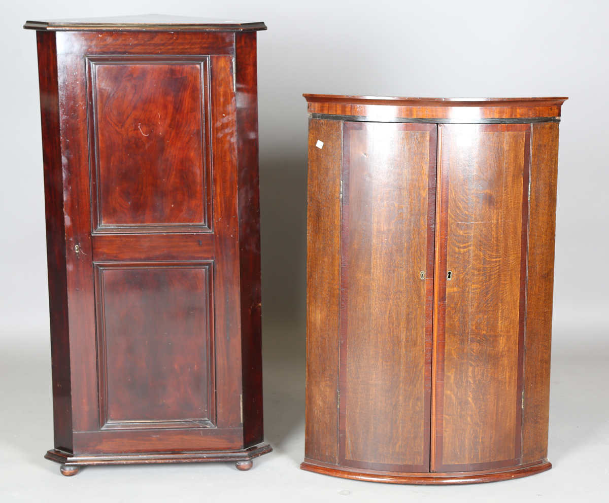 A George III oak hanging bowfront corner cabinet with mahogany crossbanded doors, height 101cm,