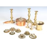 A group of metalware, including various horse brasses, three 19th century brass candlesticks, a