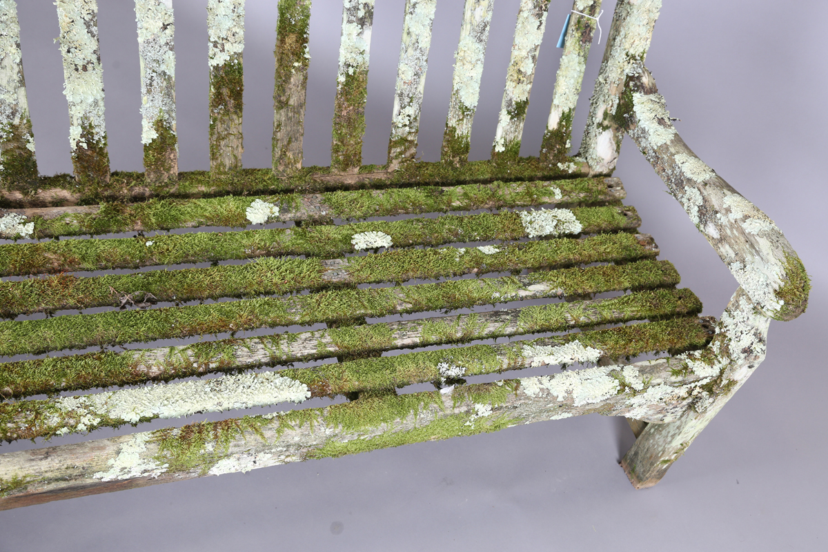 A 20th century teak garden bench, covered in green lichen, height 81cm, width 182cm, depth 70cm. - Image 8 of 11