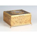 An early 20th century French gilt metal jewellery casket, the top inset with a floral painted