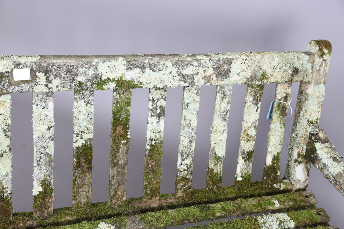 A 20th century teak garden bench, covered in green lichen, height 81cm, width 182cm, depth 70cm. - Image 10 of 11